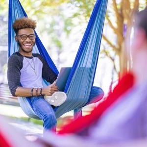 A Montevallo student enjoying swinging in a hammock on a sunny day.
